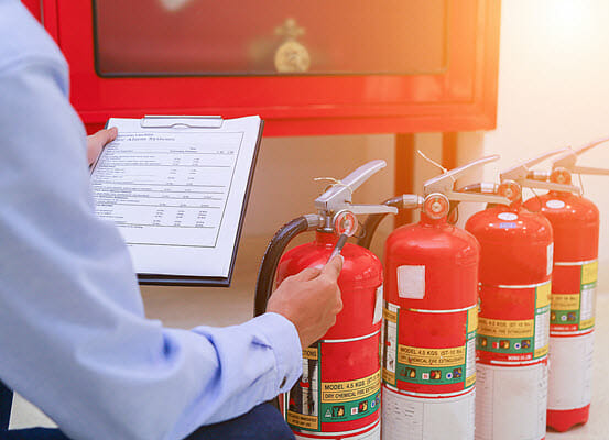 Person inspecting fire extinguishers