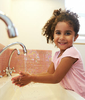Child washing their hands at sink
