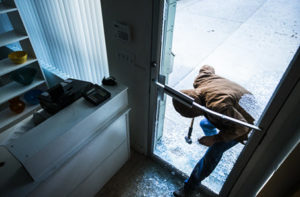 Person breaking into building through glass door